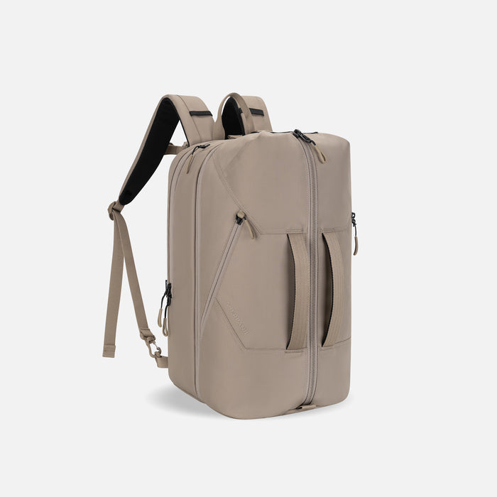 A Sherpani Juno Dune Duffel Backpack, 3/4 view showing duffle straps and main pocket on white backdrop.   #color_dune-tan
