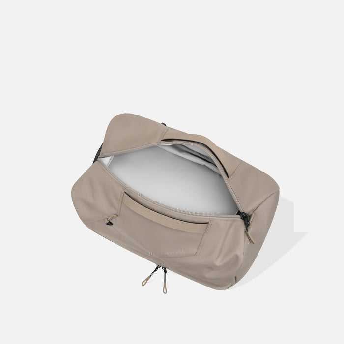 A Sherpani Juno Dune Duffel Backpack, above view showing inside main duffle pocket on white backdrop.    #color_dune-tan