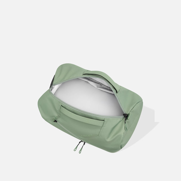 A Sherpani Juno Olivine Duffel Backpack, above view showing inside main duffle pocket on white backdrop.    #color_olivine-green