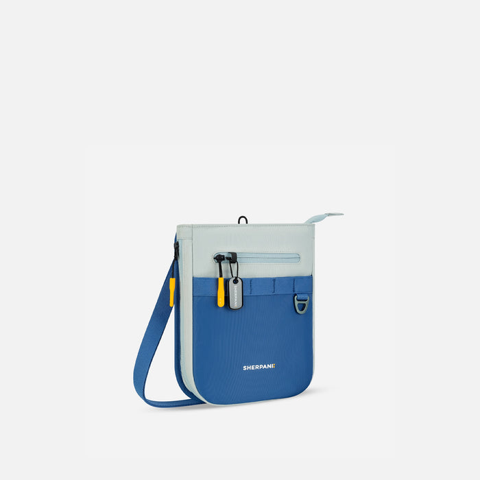 A Sherpani Lima Seastone Crossbody Purse, back view showing lockable and side pockets on white backdrop.   #color_seastone