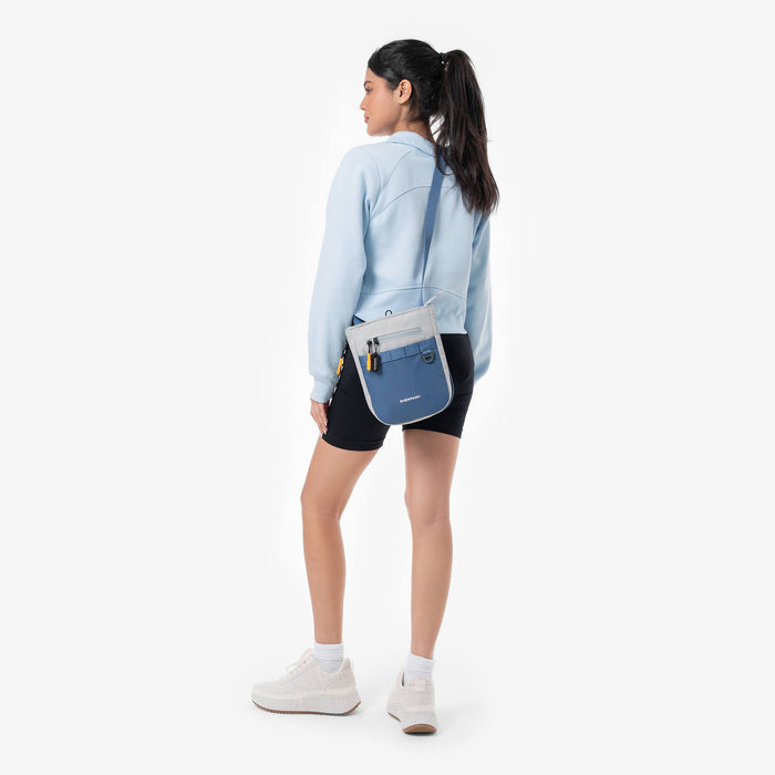 Woman wearing a Sherpani Lima Seastone Crossbody Purse against white backdrop.   #color_seastone