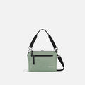 A Sherpani Mei Aloe Mist Green Anti-theft Travel Trio Crossbody, front view showing lockable pockets on white backdrop.  #color_aloe-mist-green