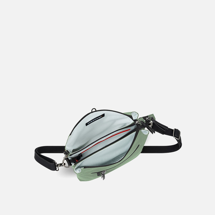 A Sherpani Mei Aloe Mist Green Anti-theft Travel Trio Crossbody, above view showing inside three main pockets white backdrop.  #color_aloe-mist-green