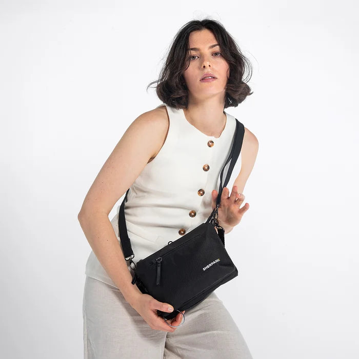 Woman wearing a Sherpani Mei Carbon Black Anti-theft Travel Trio Crossbody against white backdrop.  #color_carbon-black
