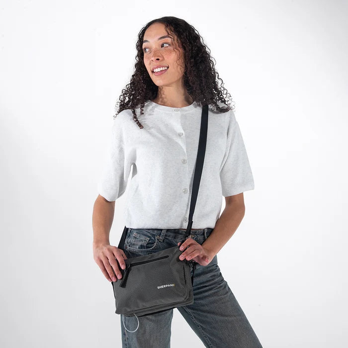 Woman wearing a Sherpani Mei Granite Anti-theft Travel Trio Crossbody against white backdrop. #color_granite-grey
