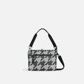 A Sherpani Mei Houndstooth Anti-theft Travel Trio Crossbody, front view showing lockable pockets on white backdrop.   #color_houndstooth-print