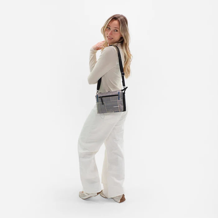 Woman wearing a Sherpani Mei Passport Anti-theft Travel Trio Crossbody against white backdrop.  #color_passport-print