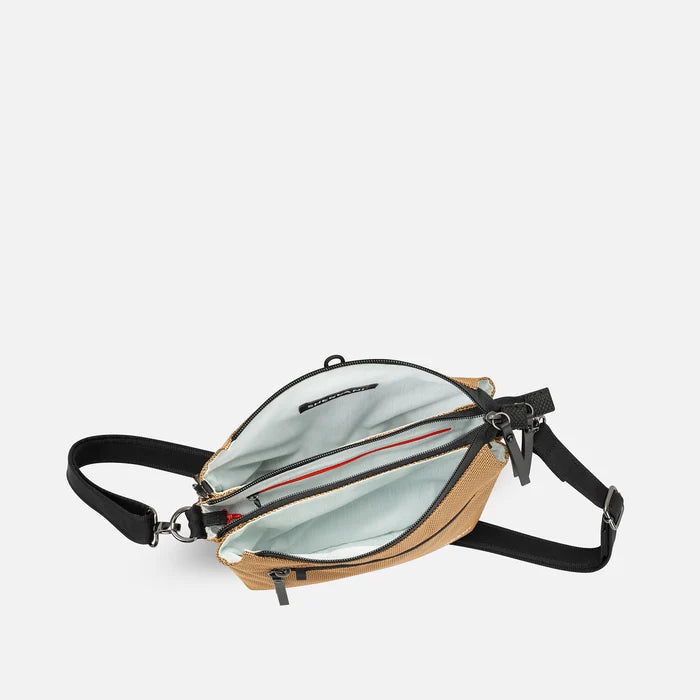 A Sherpani Mei Sand Anti-theft Travel Trio Crossbody, above view showing inside three main pockets white backdrop.   #color_sand-tan