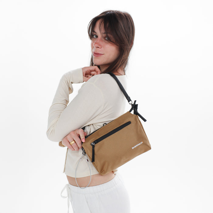 Woman wearing a Sherpani Mei Sand Anti-theft Travel Trio Crossbody against white backdrop.  #color_sand-tan