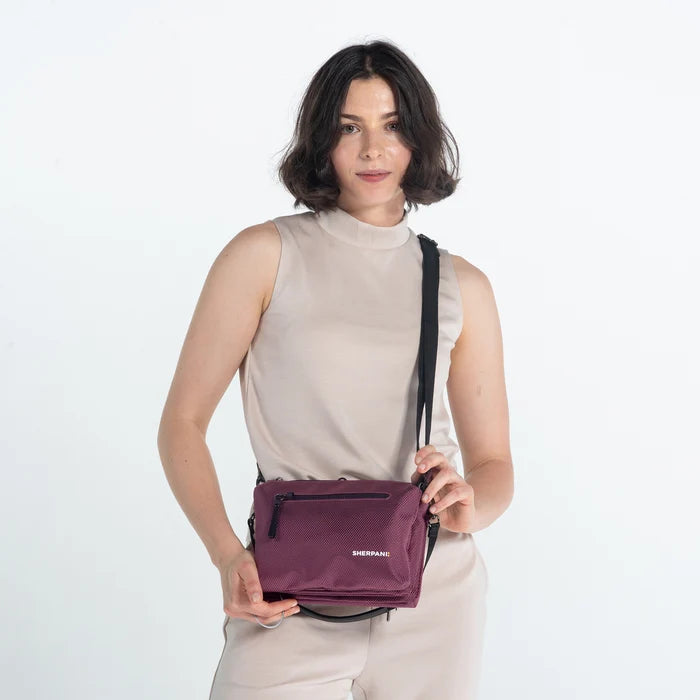 Woman wearing a Sherpani Mei Smoky Orchid Anti-theft Travel Trio Crossbody against white backdrop.  #color_smoky-orchid-pink