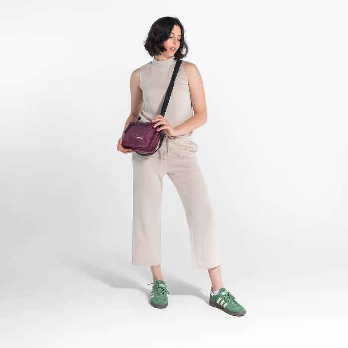 Woman wearing a Sherpani Mei Smoky Orchid Anti-theft Travel Trio Crossbody against white backdrop. #color_smoky-orchid-pink