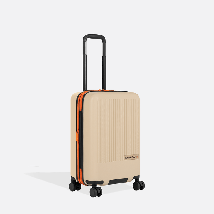 A Sherpani Meridian Chai Beige Carry-On Luggage, 3/4 view showing zipper and extender against white background.   #color_chai-beige