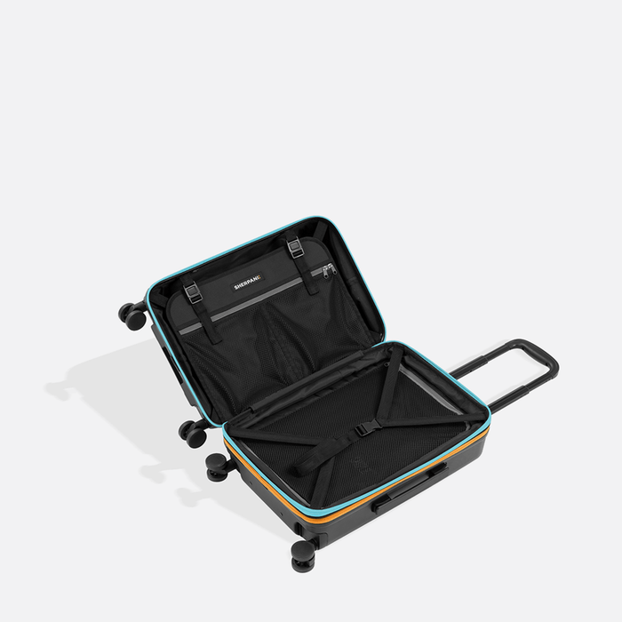 A Sherpani Meridian Chromatic Black Carry-On Luggage, above view showing inside packing spaces on white backdrop.  #color_chromatic-black