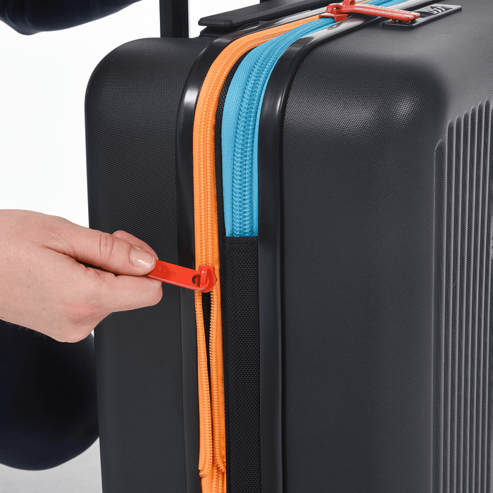 Person pulling extender zipper of a Sherpani Meridian Black Carry-On Luggage. #color_chromatic-black