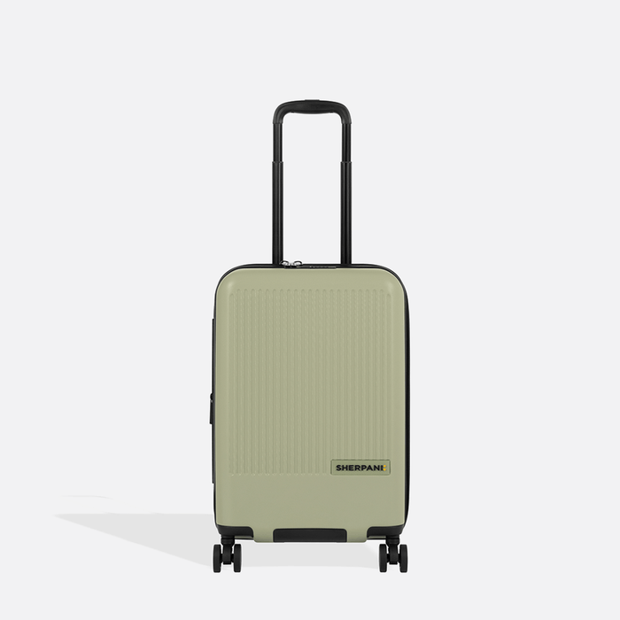 A Sherpani Meridian Matcha Carry-On Luggage, front view showing handle and zipper extender on white backdrop.  #color_matcha-green