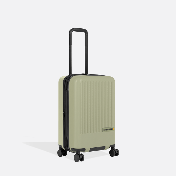 A Sherpani Meridian Matcha Carry-On Luggage, 3/4 view showing zipper and extender against white background. #color_matcha-green