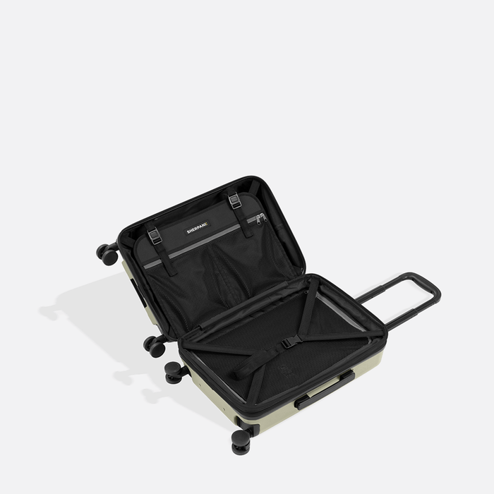 A Sherpani Meridian Matcha Carry-On Luggage, above view showing inside packing spaces on white backdrop. #color_matcha-green