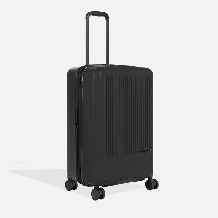 A Sherpani Meridian Black Checked-Luggage, 3/4 view showing zipper and extender against white background.  #color_black