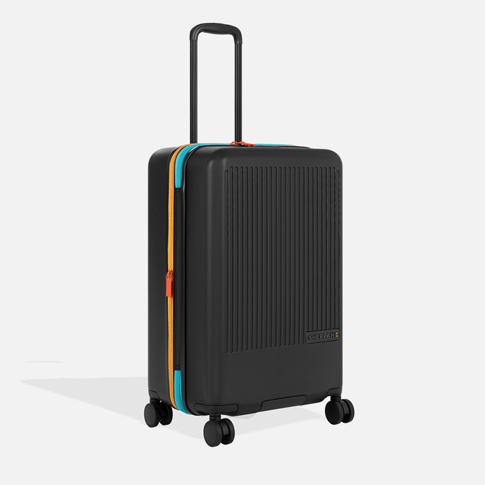 A Sherpani Meridian Chromatic Black Checked-Luggage, 3/4 view showing zipper and extender against white background.     #color_chromatic-black