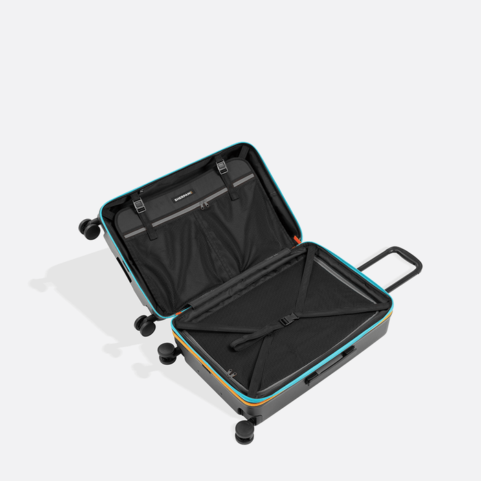 A Sherpani Meridian Chromatic Checked-Luggage, above view showing inside packing spaces on white backdrop.  #color_chromatic-black