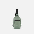 A Sherpani Metro Aloe Mist Green Anti-theft Reversible Sling, front view showing strap & lockable pocket on white background. #color_aloe-mist-green