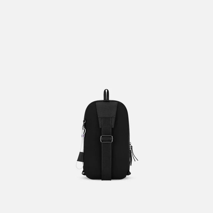 A Sherpani Metro Carbon Black Anti-theft Reversible Sling, back view showing adjustable strap and chair lock on white background. #color_carbon-black