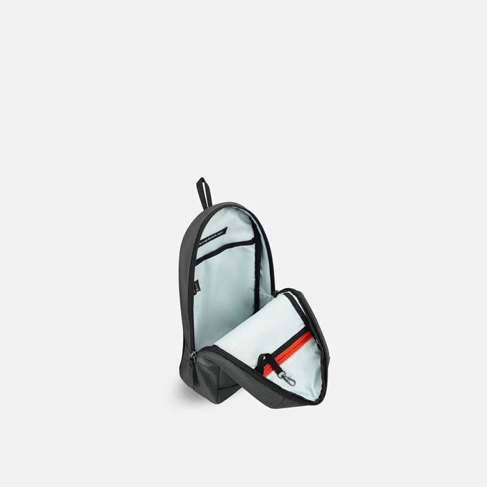 A Sherpani Metro Granite Anti-theft Reversible Sling, 3/4 view open showing inside pocket against white background. #color_granite-grey