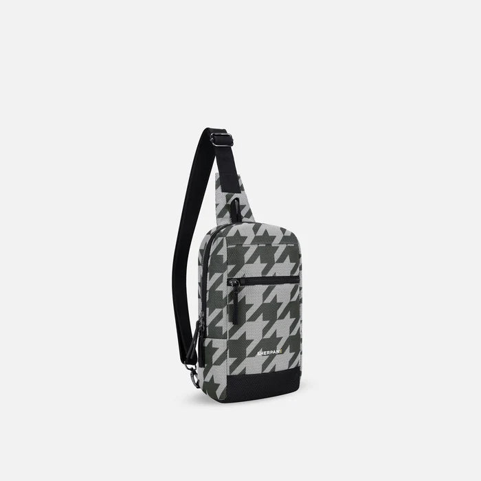 A Sherpani Metro Houndstooth Anti-theft Reversible Sling, 3/4 view showing strap & lockable pocket on white background.  #color_houndstooth-print
