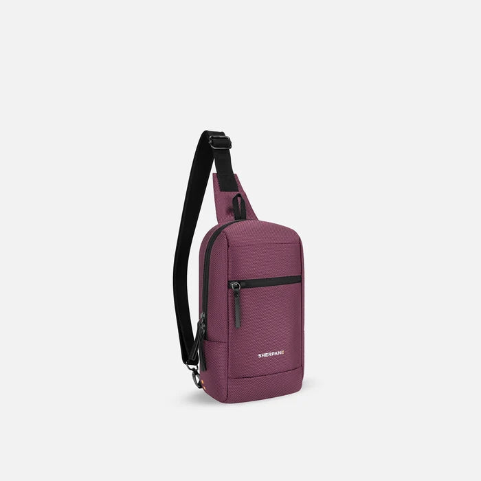A Sherpani Metro Smoky Orchid Anti-theft Reversible Sling, 3/4 view showing strap & lockable pocket on white background.  #color_smoky-orchid-pink