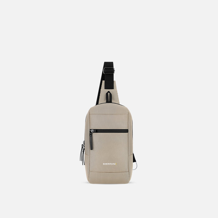 A Sherpani Metro Straw Beige Anti-theft Reversible Sling, front view showing strap & lockable pocket on white background. #color_straw-beige