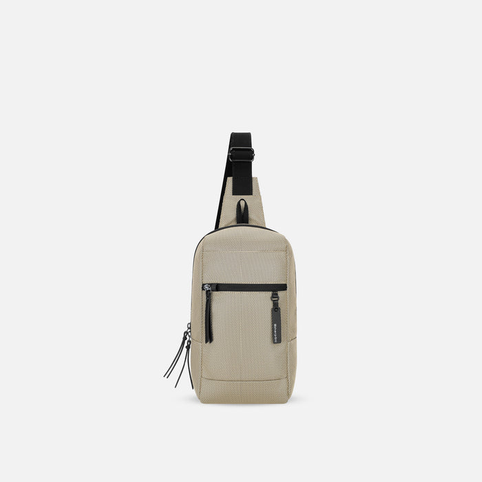 A Sherpani Metro Straw Beige Anti-theft Reversible Sling, front view showing strap & lockable pockets on white backdrop. #color_straw-signature