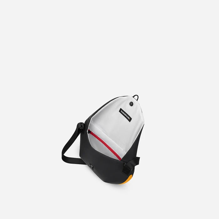A Sherpani Milli Chromatic Black Mini Messenger, above view showing inside main pocket against white backdrop.    #color_chromatic-black