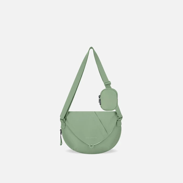 A Sherpani Milli Olivine Mini Messenger, front view showing lockable front zipper pocket against white background.  #color_olivine-green