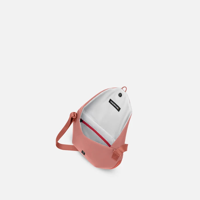 A Sherpani Milli Desert Pink Mini Messenger, above view showing inside main pocket against white backdrop.    #color_desert-pink