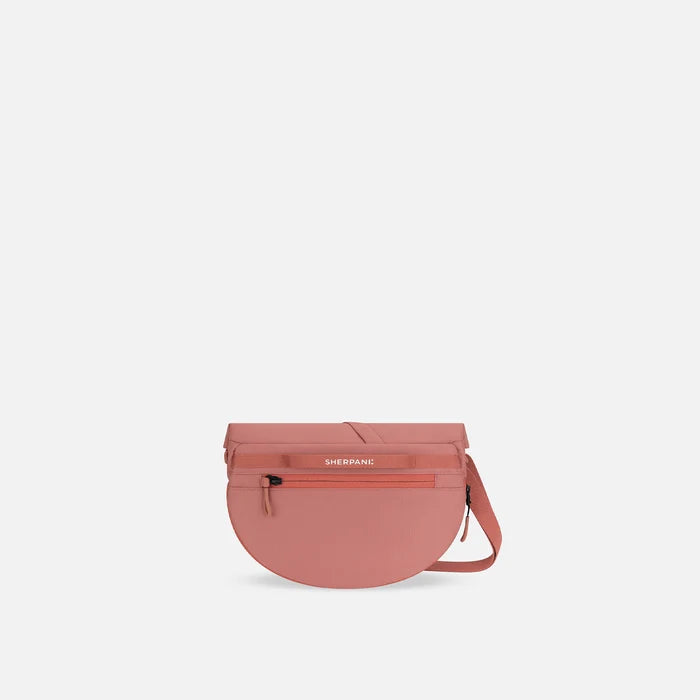 A Sherpani Milli Desert Pink Mini Messenger, back view showing black backside. #color_desert-pink