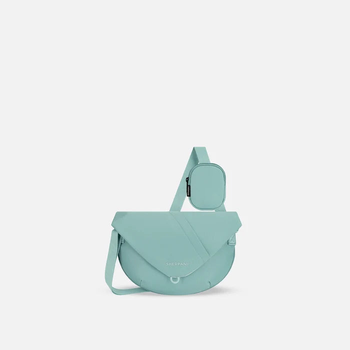A Sherpani Milli Surf Blue Mini Messenger, front view showing lockable front zipper pocket against white background.  #color_surf-blue
