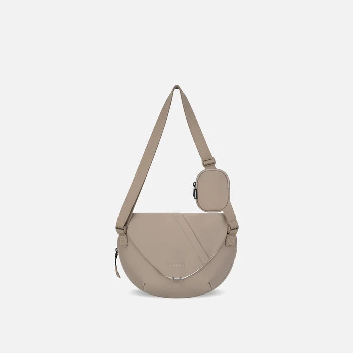 A Sherpani Milli Dune Mini Messenger, front view showing lockable front zipper pocket against white background.  #color_dune-tan
