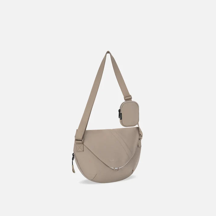 A Sherpani Milli Dune Mini Messenger, 3/4 view showing front flap pocket and strap on white backdrop.  #color_dune-tan
