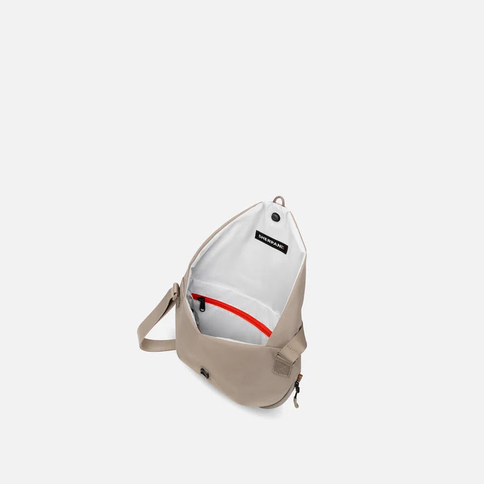 A Sherpani Milli Dune Mini Messenger, above view showing inside main pocket against white backdrop.    #color_dune-tan
