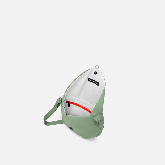 A Sherpani Milli Olivine Mini Messenger, above view showing inside main pocket against white backdrop.    #color_olivine-green