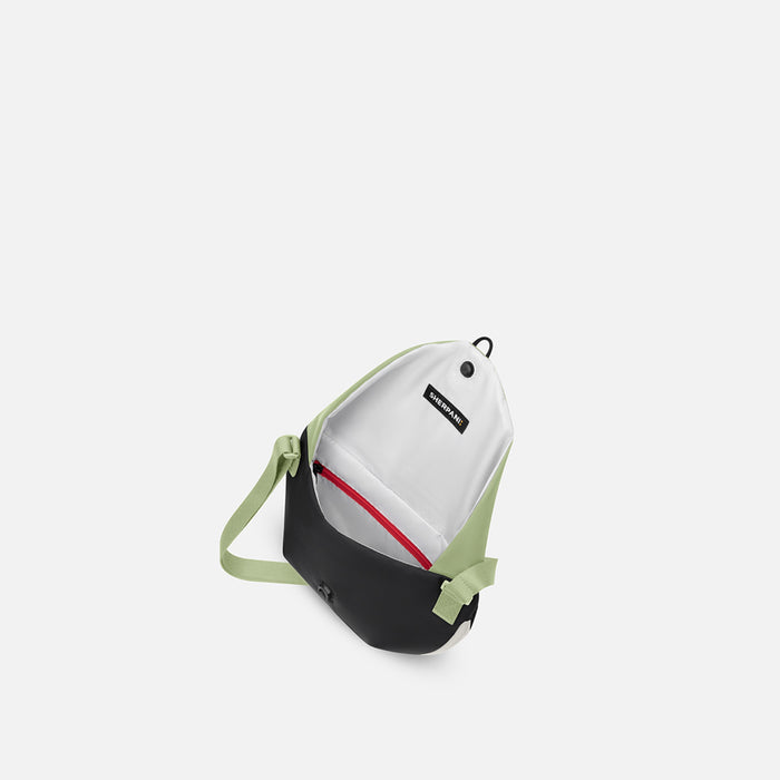 A Sherpani Milli Palm Green Mini Messenger, above view showing inside main pocket against white backdrop.    #color_palm-green