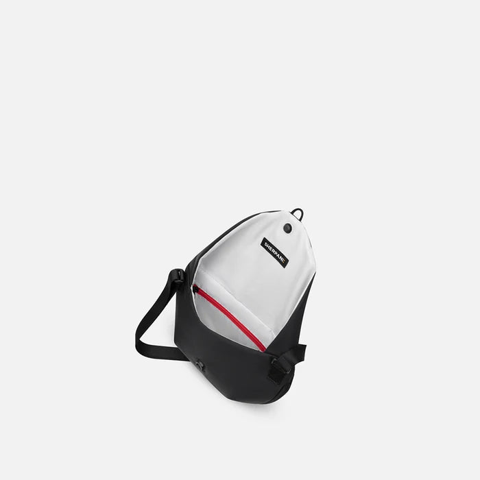 A Sherpani Milli Raven Black Mini Messenger, above view showing inside main pocket against white backdrop.    #color_raven-black