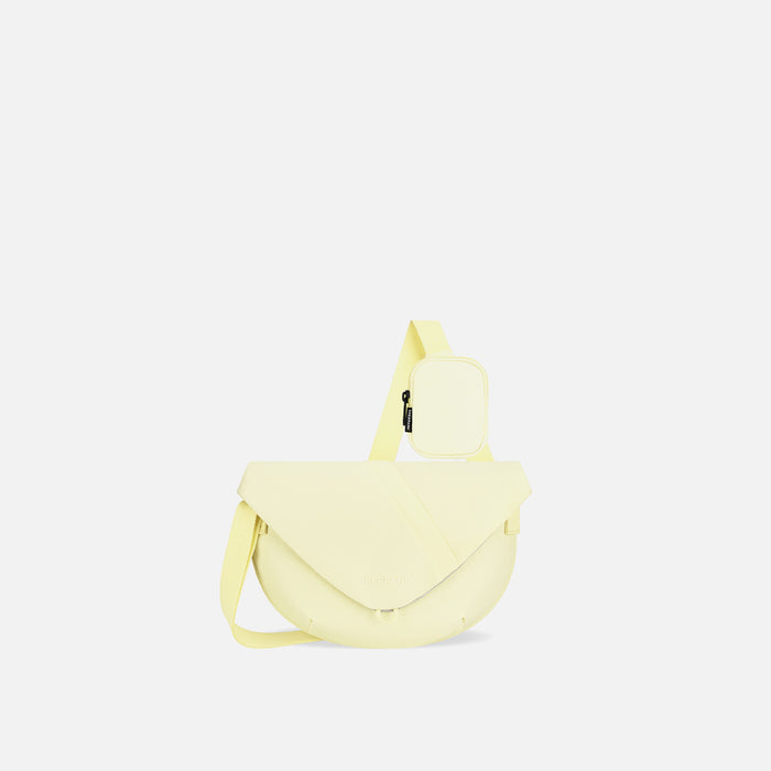 A Sherpani Milli Sol Yellow Mini Messenger, front view showing lockable front zipper pocket against white background.  #color_sol-yellow