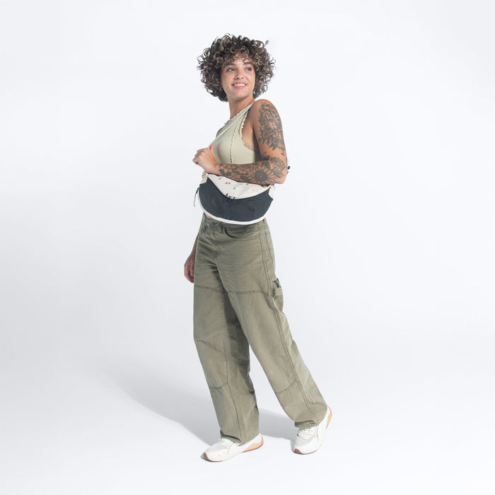 A woman holding a Sherpani Milli Terrazzo Print Mini Messenger against a white background.  #color_terrazzo-print