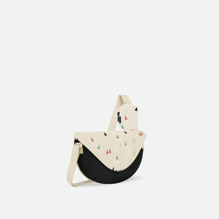 A Sherpani Milli Terrazzo Print Mini Messenger, 3/4 view showing front flap pocket and strap on white backdrop.   #color_terrazzo-print