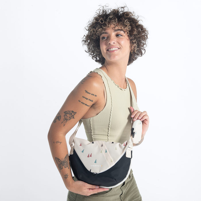 A woman wearing a Sherpani Milli Terrazzo Print Mini Messenger against a white background.  #color_terrazzo-print