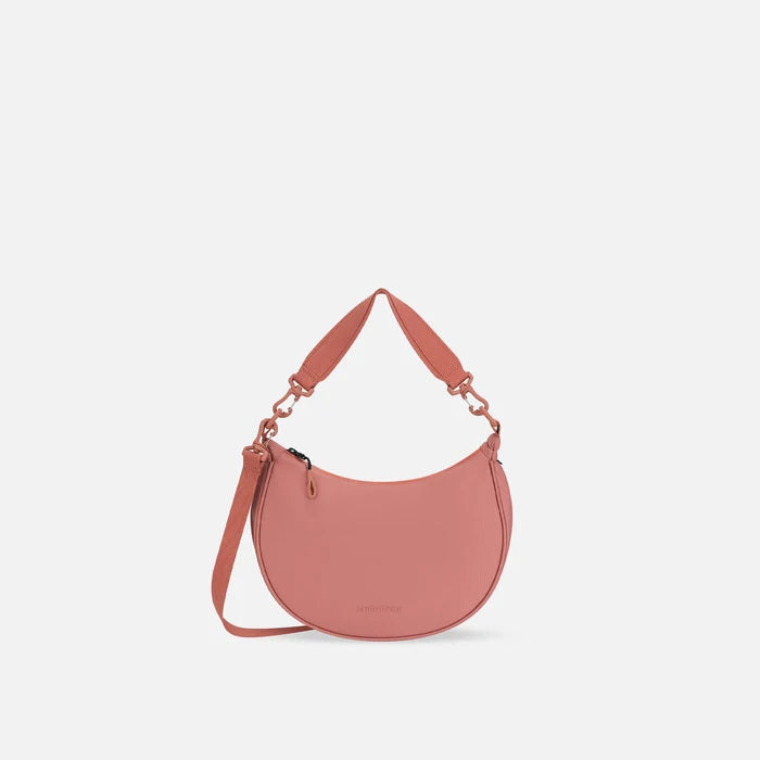 A Sherpani Mina Desert Pink Medium Crossbody Bag, front view showing strap options on white background.  #color_desert-pink