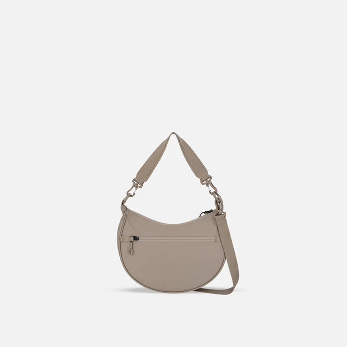 A Sherpani Mina Dune Medium Crossbody Bag, back view showing straps and lockable pocket on white background.  #color_dune-tan