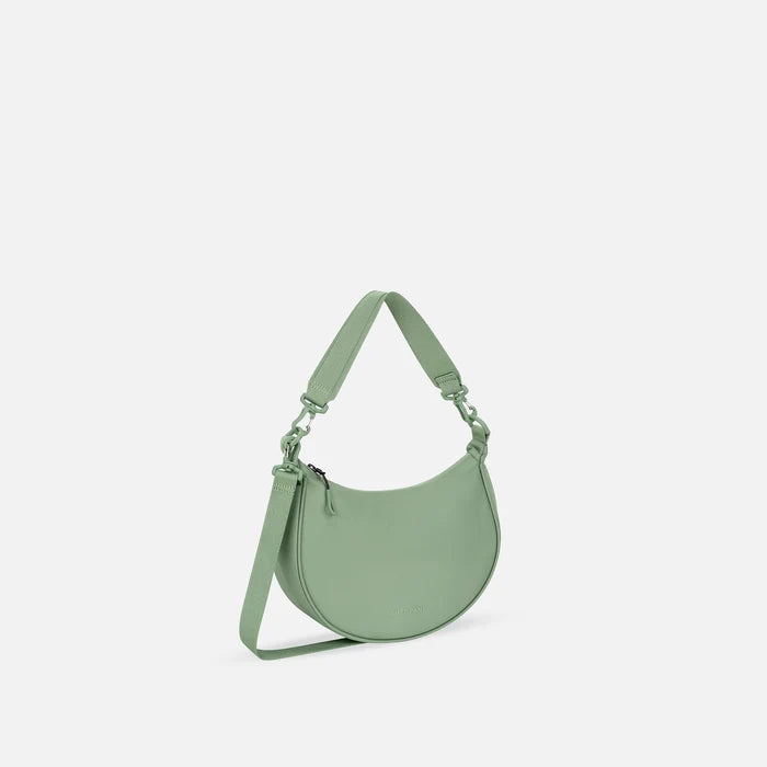 A Sherpani Mina Olivine Medium Crossbody Bag, 3/4 view showing strap options on white background.  #color_olivine-green