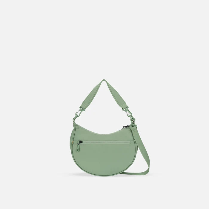 A Sherpani Mina Olivine Medium Crossbody Bag, back view showing straps and lockable pocket on white background.  #color_olivine-green